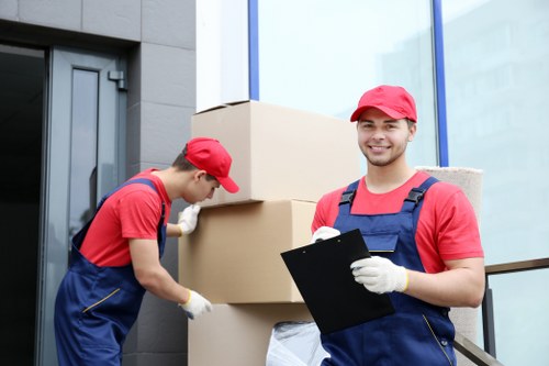 Professional movers carrying furniture through a residential flat entrance